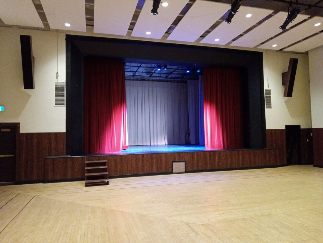 The Upstairs Hall's raised stage, its curtains lit in pink and blue